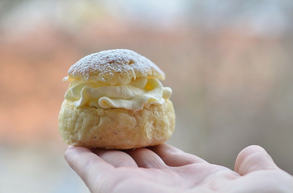 Någon räcker fram en semla.