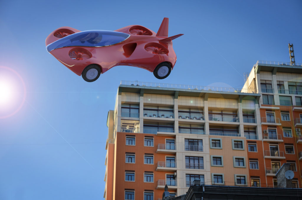 Röd bil som flyger över ett hus.