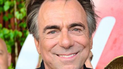 Rikard Wolff ler mot kameran. Han har svart hår som är grått vid tinningarna och har ganska mycket rynkor. Han har en svart skinnjacka på sig,