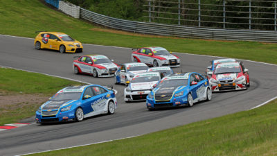 Många bilar åker i en kurva.