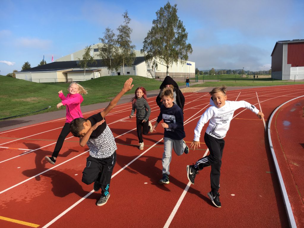 Sex barn springer på en löpbana.
