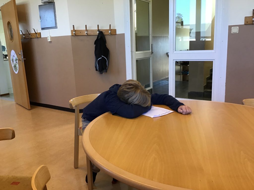 Ett barn ligger och sover på ett bord.