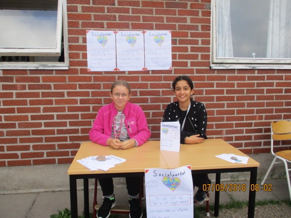 Två elever vid ett bord intill skolans tegelvägg.