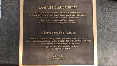 En fyrkantiga skiva av metall med text på.