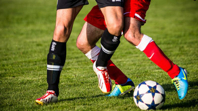 Foto på två fotbollsspelare, bara benen syns.