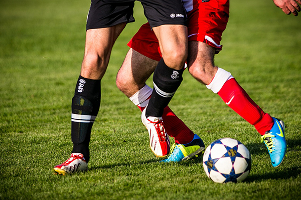 Foto på två fotbollsspelare, bara benen syns.