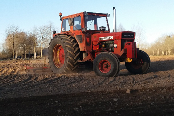 En röd Volvo BM på en åker.