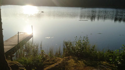 Foto på en solnedgång i ett spegelblankt vattendrag.