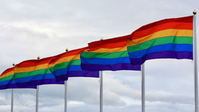 Prideflaggor som vajar i vinden.